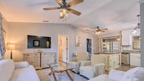A modern living room with a glass coffee table, white sofas, and ceiling fans. - Charming Ocala Home Near World Equestrian Center! (Ocala)