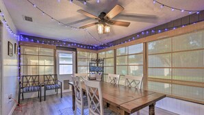 A dining area with a wooden table, white chairs, and a ceiling fan. - Charming Ocala Home Near World Equestrian Center! (Ocala)