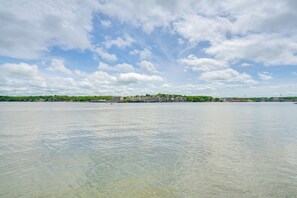 A waterfront view with buildings along the shore, clear water, and a partly cloudy sky. - 2 Decks, Lake Views! Group Escape in Osage Beach (Osage Beach)