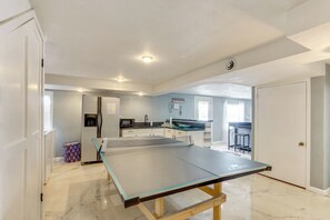 A spacious room with a ping pong table, a kitchen area, and a dining area. - 2 Decks, Lake Views! Group Escape in Osage Beach (Osage Beach)