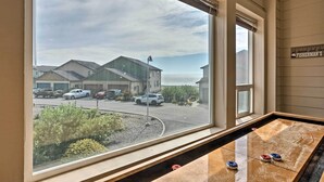 Blick aus einem Fenster auf einen Parkplatz und ein Gebäude mit der Aufschrift „FISHERMAN'S“. Im Vordergrund steht ein Billardtisch.