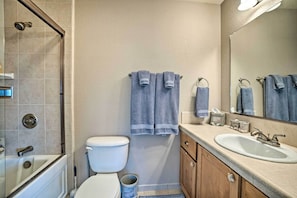 Une salle de bain équipée d’une baignoire, de toilettes, d’un lavabo et d’un miroir.