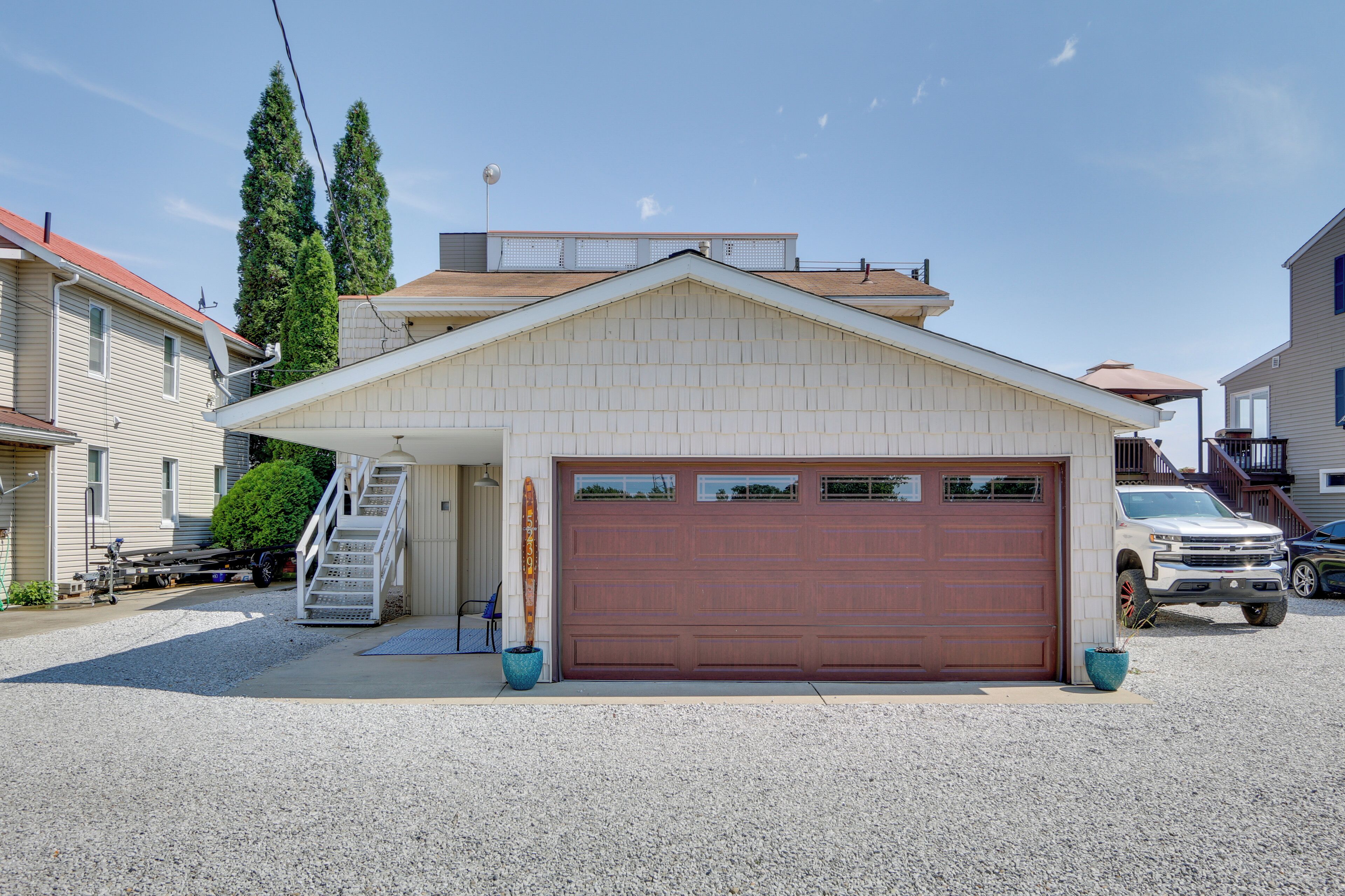 A single-story house with a garage, a covered porch, and a small staircase leading to the garage.