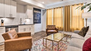 A modern kitchen with white cabinets, a dishwasher, and a large window with curtains. - Trendy Apt w/ Laundry Machines < 3 Mi to Dtwn (Philadelphia)