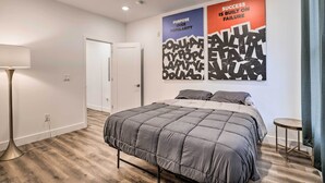 A modern bedroom with a large bed, a bedside table, and two motivational posters on the wall. - Trendy Apt w/ Laundry Machines < 3 Mi to Dtwn (Philadelphia)