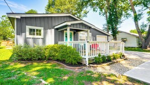 A single-story house with a front porch, a garage, and a small front yard with a gravel path and grass. - Pet-friendly Cottage, 3 Blocks to Main St! (Tomball)