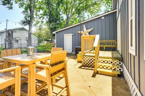 A wooden deck with a table and chairs, a wooden bench, and a star decoration. - Pet-friendly Cottage, 3 Blocks to Main St! (Tomball)