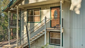 A two-story house with a front porch, a staircase, and a large wooden door. - Twain Harte Home - Perfect for Large Families (Twain Harte)