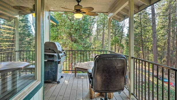 A covered outdoor deck with a grill, a table, and a chair. - Twain Harte Home - Perfect for Large Families (Twain Harte)