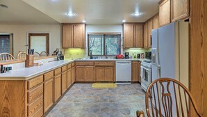 A kitchen with wooden cabinets, a central island, a dishwasher, and a refrigerator. - Twain Harte Home - Perfect for Large Families (Twain Harte)