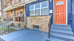 A two-story townhouse with a stone facade, a red door, and a blue exterior. - Philadelphia Home Rental Near Center City! (Philadelphia)