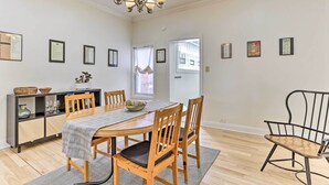 A dining area with a wooden table, chairs, a chandelier, and framed certificates on the wall. - Philadelphia Home Rental Near Center City! (Philadelphia)