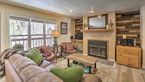 A cozy living room with a fireplace, leather sofa, and a television. - Walk to Marina: Rustic Grand Lake Retreat! (Grand Lake)