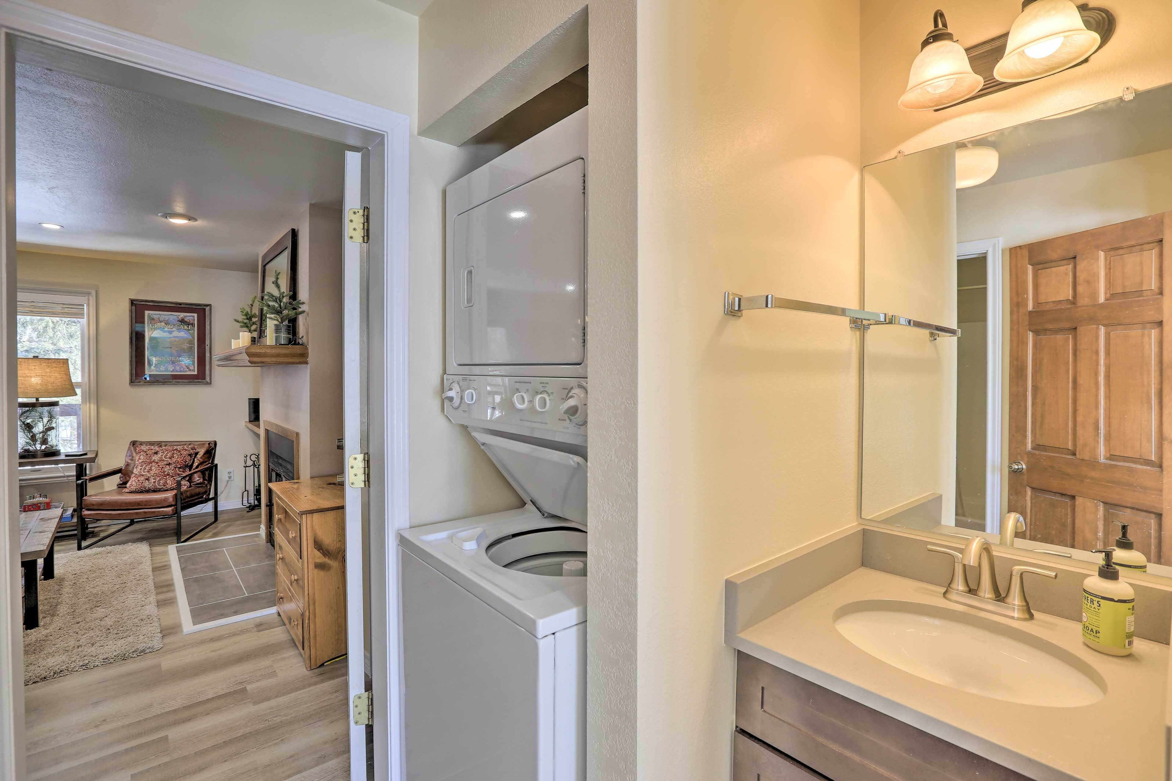 A laundry area with a washing machine, a wooden chair, and a rug.