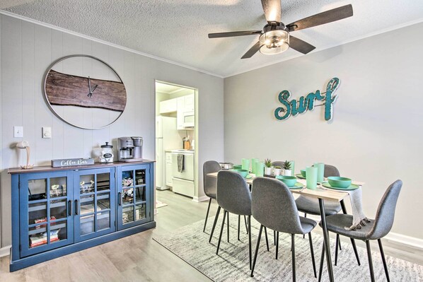 A dining area with a table, chairs, and a ceiling fan.