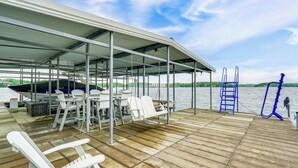A covered outdoor deck with seating and a view of the water. - Water Sports On-site! Lake of the Ozarks Townhome (Lake Ozark)