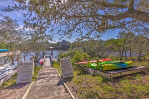 A wooden dock leading to a beach with kayaks and a sign indicating beach services and rules. - 30A Retreat w/ Patio & Resort Amenities! (Santa Rosa Beach)