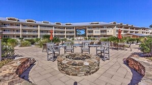 A hotel with a courtyard featuring outdoor seating, a stone fire pit, and a swimming pool. - 30A Retreat w/ Patio & Resort Amenities! (Santa Rosa Beach)