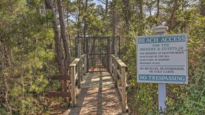 A wooden boardwalk leading to a beach access point with a sign indicating no bicycles, skateboards, or golf carts, and no trespassing. - 30A Retreat w/ Patio & Resort Amenities! (Santa Rosa Beach)