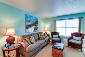 A living room with a sofa, two armchairs, a coffee table, a lamp, and a painting on the wall. - Destin Townhome w/ Balcony - Walk to the Beach! (Miramar Beach)