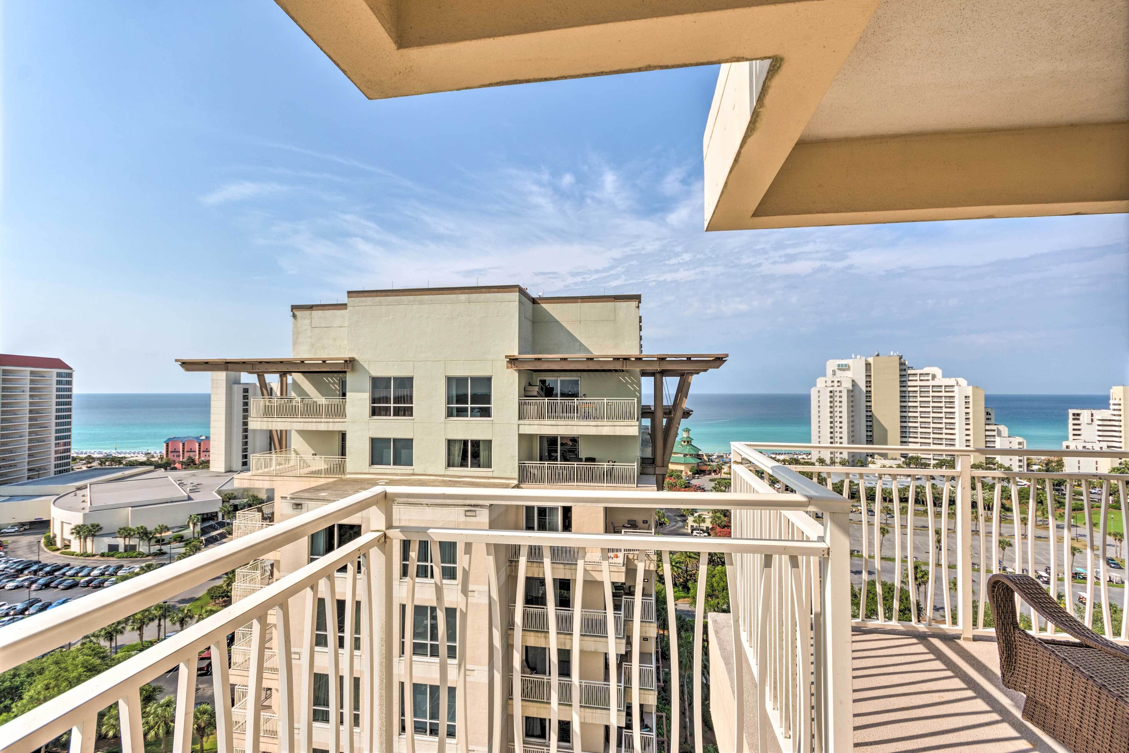 A high-rise building with multiple balconies overlooking a coastal area.