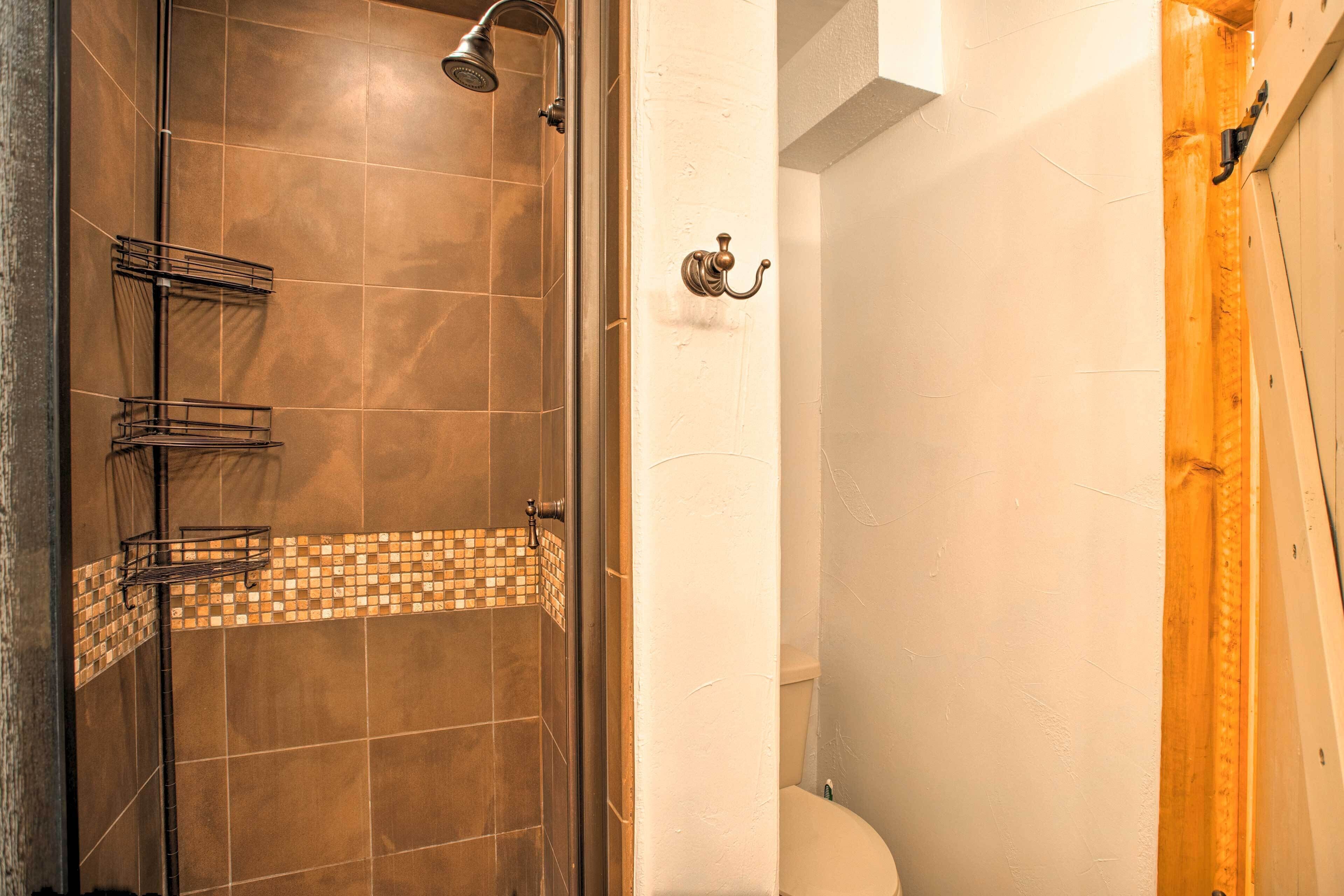 Un baño con ducha, inodoro y lavabo.