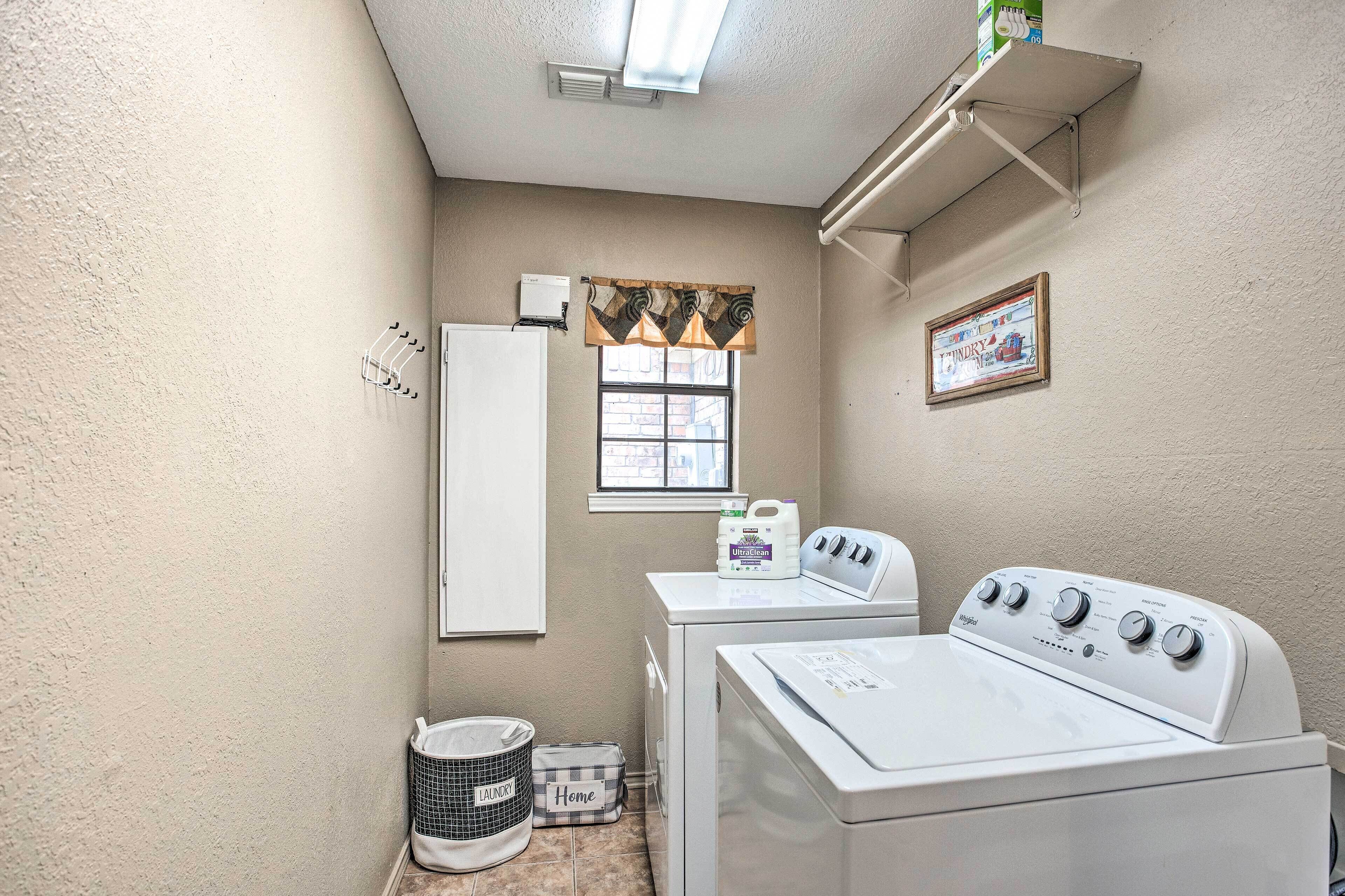 A laundry room with a washing machine, dryer, and a window with a view.