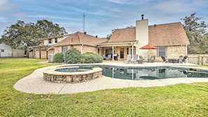 A residential backyard with a swimming pool, a covered patio area, and a brick house. - Gainesville Home w/ Outdoor Oasis, 16 Mi to Lake (Gainesville)