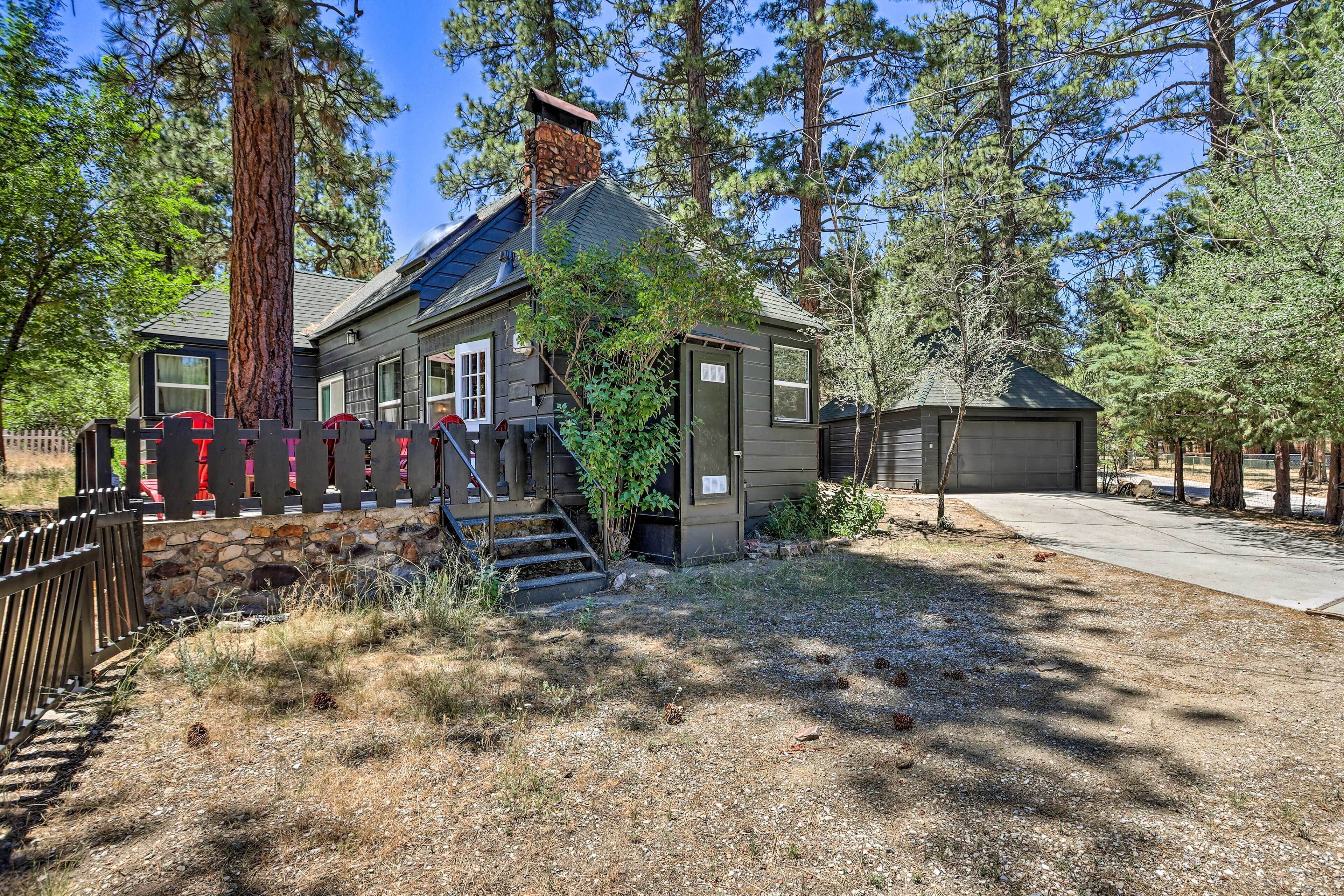 A two-story house with a stone foundation, a chimney, and a small attached garage.