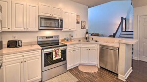 A modern kitchen with white cabinetry, stainless steel appliances, and a built-in dishwasher. - Legends Golf & Resort Townhouse: Resort Amenities! (Myrtle Beach)