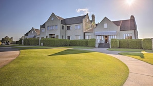 A large, multi-story house with a well-maintained lawn and hedges. - Legends Golf & Resort Townhouse: Resort Amenities! (Myrtle Beach)