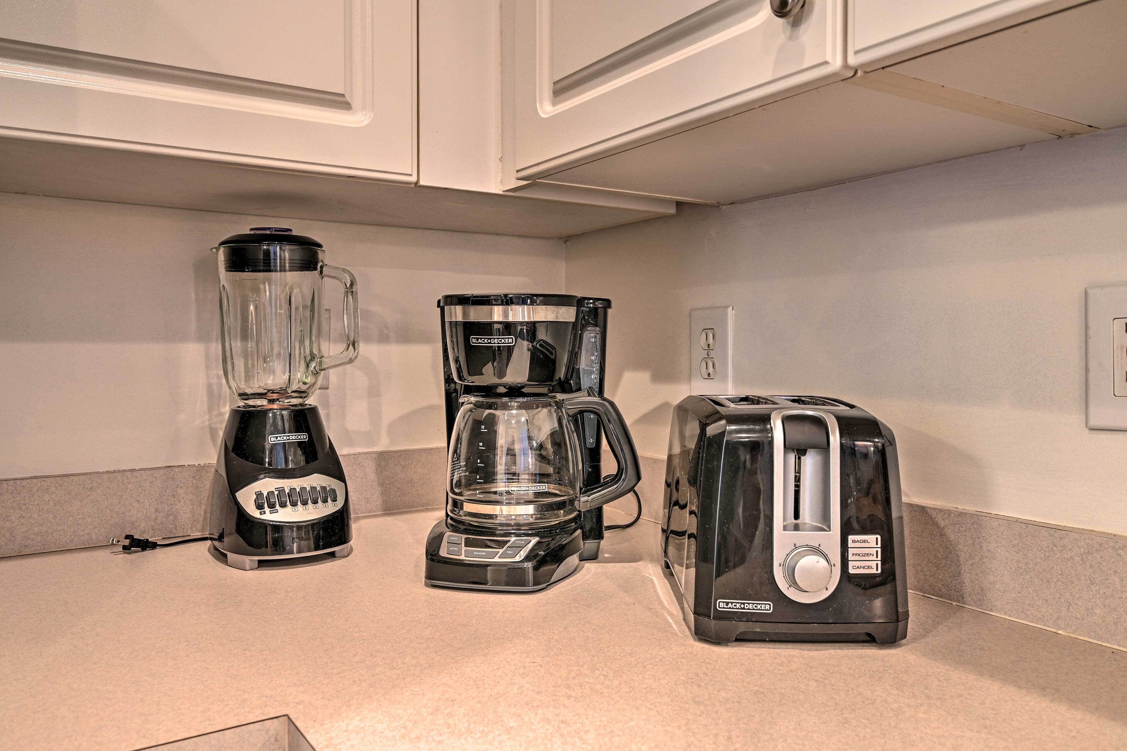 Eine Küchenarbeitsplatte mit einem Mixer, einer Kaffeemaschine und einem Toaster.