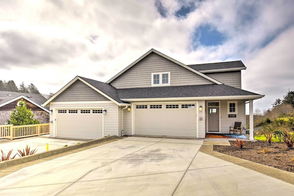 A two-story house with a garage, a covered porch, and a driveway.