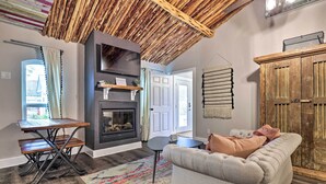 A cozy living room with a fireplace, a sofa, a wooden table, and a ceiling with a natural wood finish. - Fredericksburg 'regan Cottage' w/ Hot Tub! (Fredericksburg)