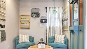 A cozy living room with teal sofas, a wooden coffee table, and decorative wall art. - Fredericksburg 'regan Cottage' w/ Hot Tub! (Fredericksburg)