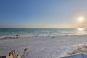 A beach with a clear sky, the sun setting over the ocean, and people relaxing on the sand. - 30A Cute Modern Cottage in Seagrove Beach (Santa Rosa Beach)