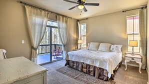 A bedroom with a bed, a ceiling fan, a nightstand, and a window with curtains. - Ski-in/out Granby Home w/ Gas Grill & Fire Pit! (Granby)