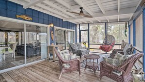 A covered outdoor seating area with wicker furniture and a ceiling fan. - Riverfront Retreat w/ Patio in Withlacoochee (Bushnell)
