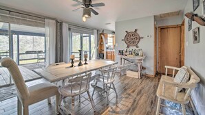 A dining area with a wooden table and chairs, a ceiling fan, and a view through large windows. - Riverfront Retreat w/ Patio in Withlacoochee (Bushnell)