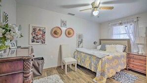A bedroom with a bed, a chair, a dresser, a ceiling fan, and a window with curtains. - Riverfront Retreat w/ Patio in Withlacoochee (Bushnell)