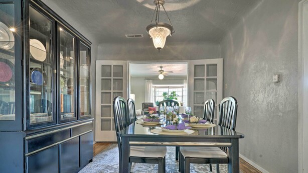 A dining area with a glass-top table, black chairs, and a chandelier. - El Paso Home w/ Backyard + Outdoor Fireplace! (El Paso)