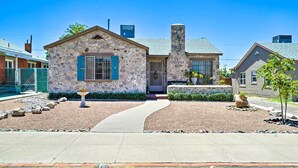 A stone house with a stone chimney, a front porch, and a gravel driveway. - El Paso Home w/ Backyard + Outdoor Fireplace! (El Paso)