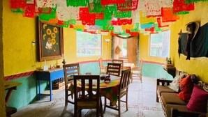 A dining area with a table and chairs, a painting on the wall, and colorful paper decorations. - RANCHO CUMBRE MONARCA  (Ocampo)
