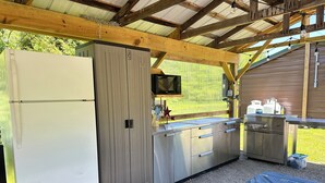 A compact kitchen area with a refrigerator, microwave, and sink.