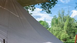 A tent with a pink flamingo decoration and a red broom.
