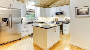 A modern kitchen with white cabinets, stainless steel appliances, and a wooden ceiling. - 'creekside Hideaway' w/ Fire Pit + Creek Access! (Mountain View)