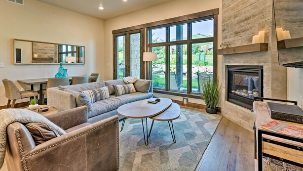 Una sala de estar moderna con chimenea, ventanas amplias y una zona de comedor.