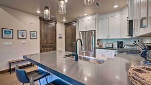 Una cocina moderna con una isla grande, electrodomésticos de acero inoxidable y armarios de madera.