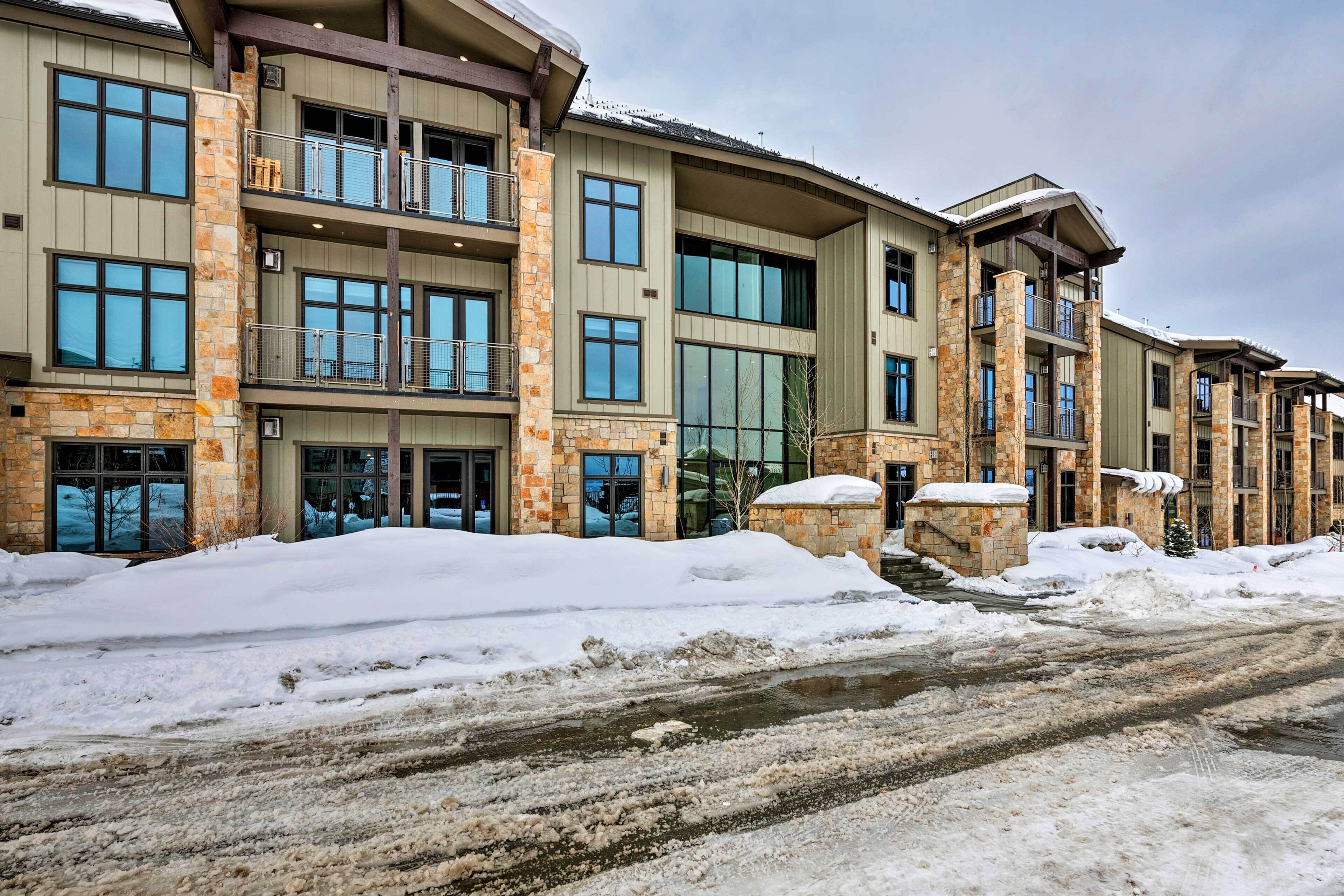 A multi-story hotel with stone and wood exterior, large windows, and balconies.