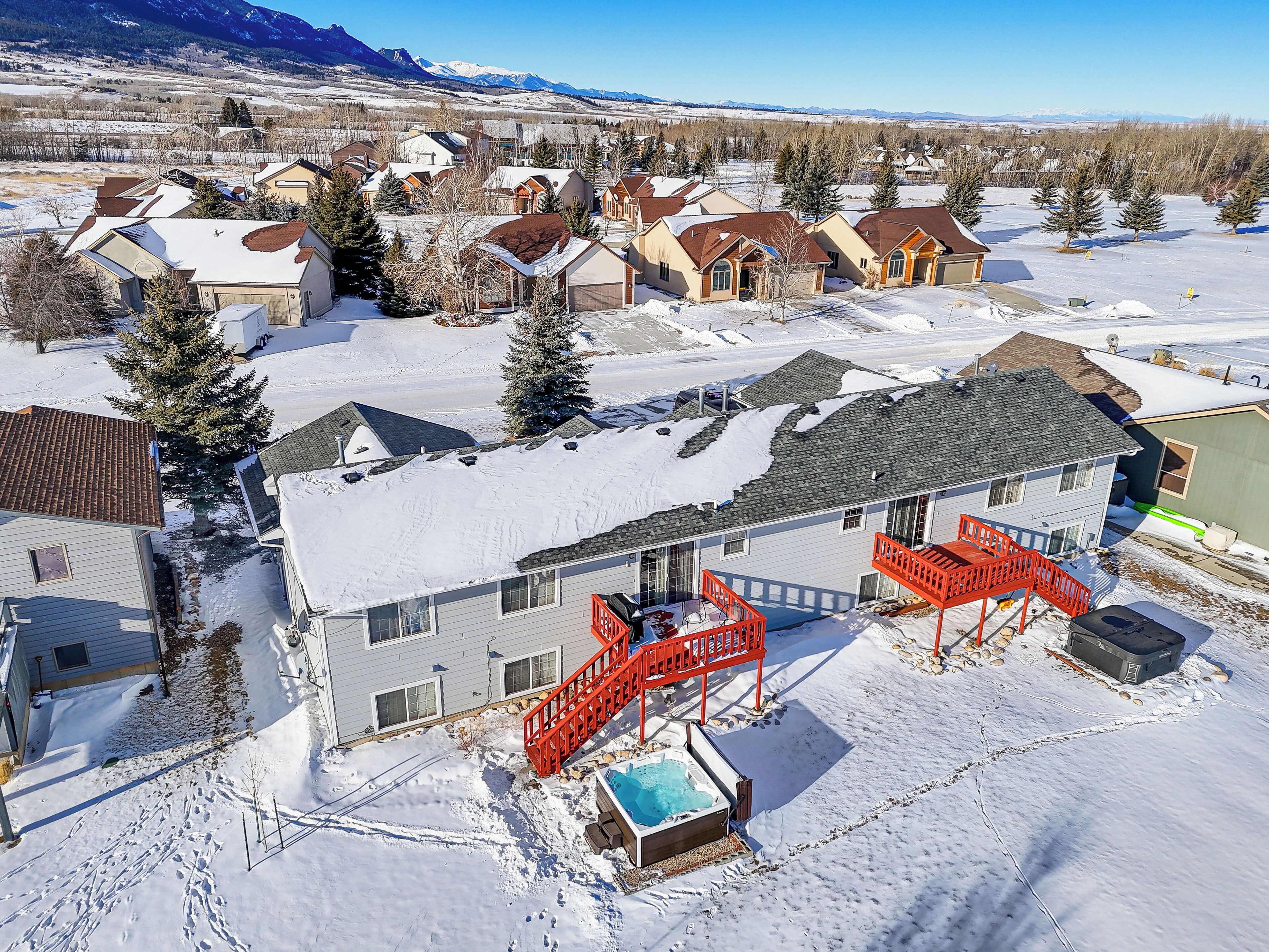 Un quartier résidentiel avec des maisons, une piscine et un escalier rouge menant à une terrasse.